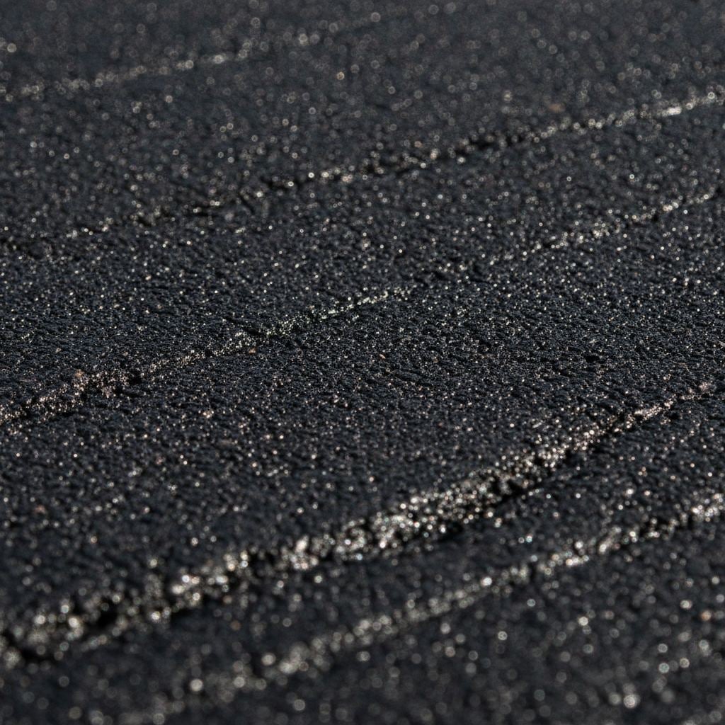 gros plan sur la texture d'un enrobé noir fraîchement posé et compacté