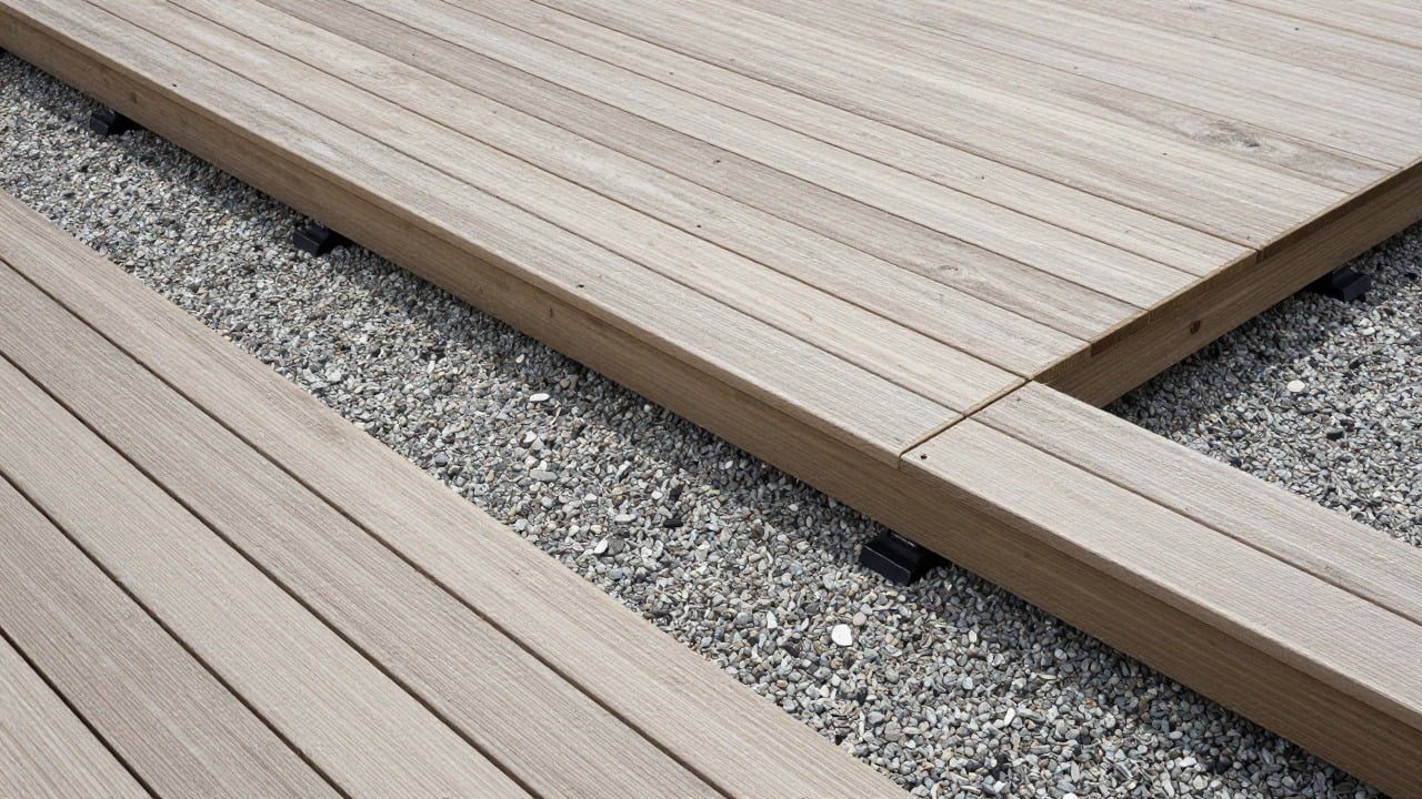 Overhead view of a composite deck terrace layout with boards, joists and adjustable pedestals laid out on a gravel base